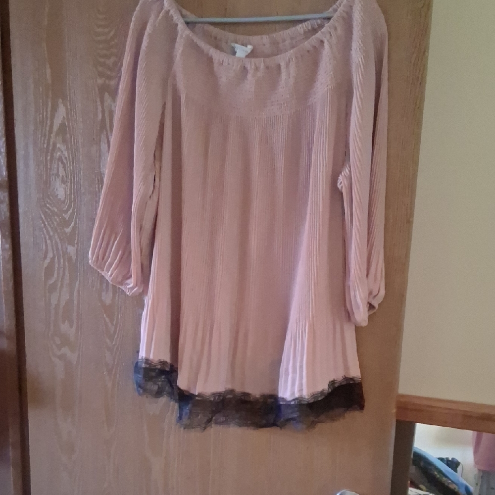 A mauve colored blouse with black lace around the bottom,made of  nylon .
